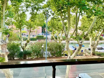 a view of a park with trees and a fountain at Le Quai Secret d'Augustine centre &vue canal avec draps serviettes et ménage in Narbonne