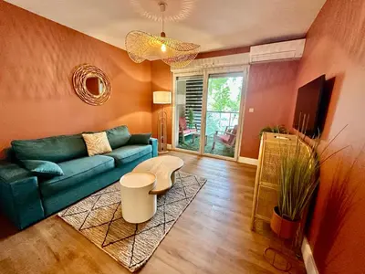 a living room with a blue couch and a table at Le Quai Secret d'Augustine centre &vue canal avec draps serviettes et ménage in Narbonne