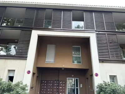 a building with black shutters on the front of it at Le Quai Secret d'Augustine centre &vue canal avec draps serviettes et ménage in Narbonne