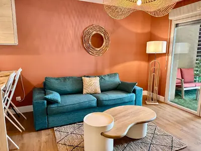 a living room with a blue couch and a table at Le Quai Secret d'Augustine centre &vue canal avec draps serviettes et ménage in Narbonne
