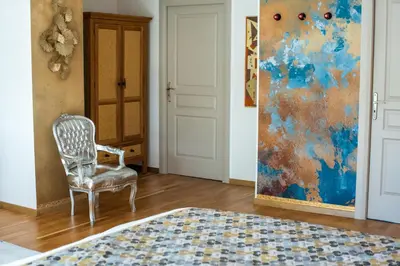 a chair in a room with a painting on the wall at Chez PhiL in La Pomarède