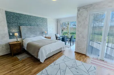 a bedroom with a bed and a table and chairs at Chez PhiL in La Pomarède
