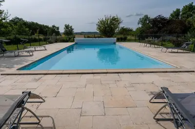 a large swimming pool with chairs around it at Chez PhiL in La Pomarède