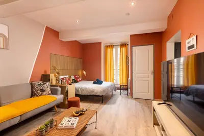 a living room with a bed and a couch at Le Limouxin jungle Wifi, petit balcon *Oc Keys in Limoux