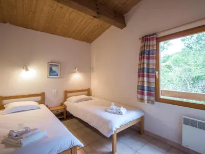 two beds in a room with a window at Mountain Retreat w Terrace in Quillan