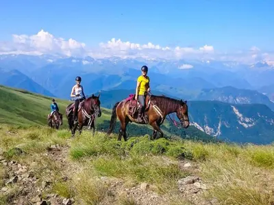 three people riding horses on a hill in the mountains at Mountain Retreat w Terrace in Quillan