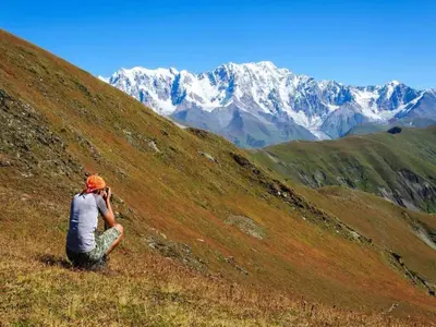 a person sitting on a hill taking a picture of a mountain at Scenic Retreat w Terrace in Quillan