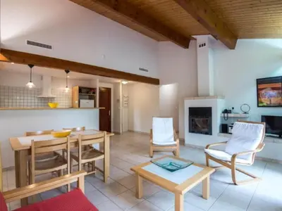 a living room with a table and chairs and a kitchen at Scenic Retreat w Terrace in Quillan