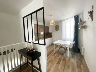 a living room with a table and a dining room at Charmante maison au village in Gruissan