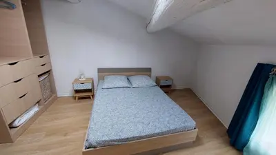 a bedroom with a bed with blue pillows on it at Charmante maison au village in Gruissan