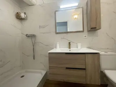 a bathroom with a sink and a toilet and a mirror at Charmante maison au village in Gruissan