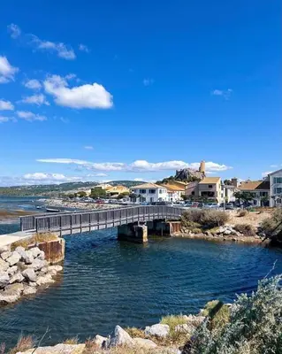 a bridge over a body of water with buildings at Charmante maison au village in Gruissan