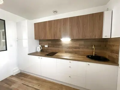 a kitchen with white cabinets and a sink at Charmante maison au village in Gruissan