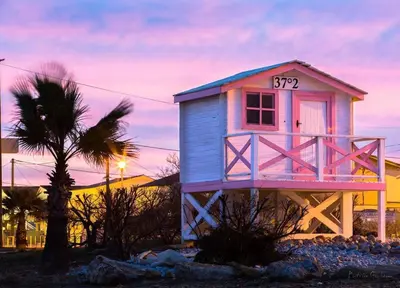 a pink and blue house with a sign on it at Charmante maison au village in Gruissan