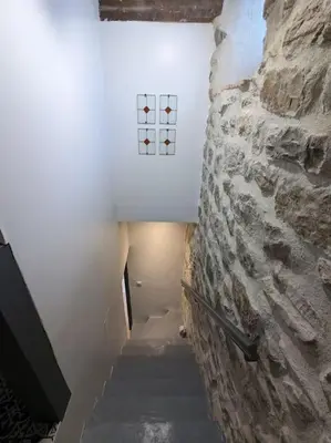 a staircase in a room with a stone wall at Maison Porte Saint Croix in Bize-Minervois