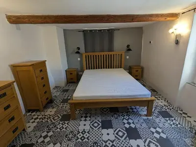a bedroom with a bed and a room with a floor with at Maison Porte Saint Croix in Bize-Minervois
