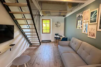 a living room with a couch and a staircase at Les gîtes du Canal du midi - Gîte Loft'Oten in Avignonet-de-Lauragais