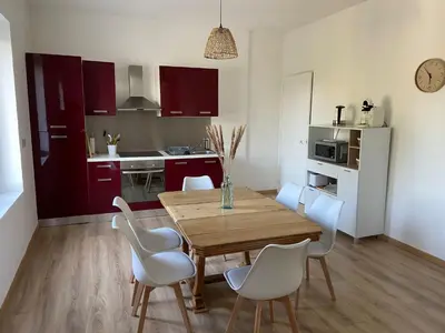 a kitchen and dining room with a wooden table and chairs at Maison La Vielmuroise in Vielmur-sur-Agout