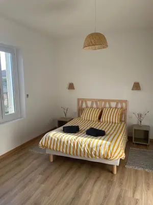 a bedroom with a bed with a yellow and white comforter at Maison La Vielmuroise in Vielmur-sur-Agout