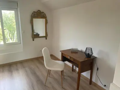 a desk with a white chair and a mirror at Maison La Vielmuroise in Vielmur-sur-Agout