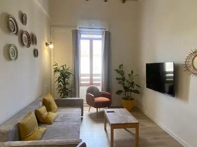 a living room with a couch and a table at T3 bord canal du midi, piscine in Homps