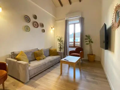 a living room with a couch and a table at T3 bord canal du midi, piscine in Homps