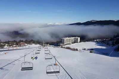 a ski lift with empty chairs in the snow at Logement dans chalet à la montagne in Montferrier