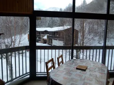 a bedroom with a yellow bed and a kitchen at Logement dans chalet à la montagne in Montferrier