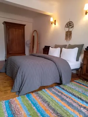a bedroom with a large bed and a rug at Maison isivier in Magrie