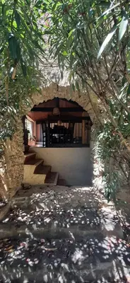 a building with a stone archway with stairs and trees at Maison isivier in Magrie