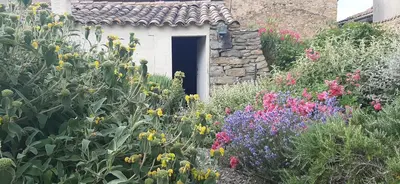 a garden with colorful flowers in front of a door at Maison isivier in Magrie