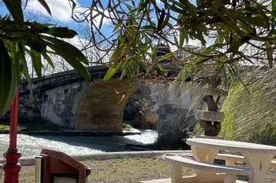 a couple of benches sitting next to a bridge at Studio pour 2 personnes proche Canal du Midi - Ventenac en Minervois in Ventenac en Minervois