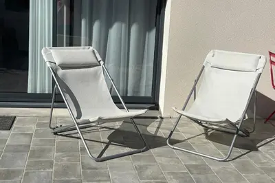 two white chairs sitting next to a building at Studio pour 2 personnes proche Canal du Midi - Ventenac en Minervois in Ventenac en Minervois