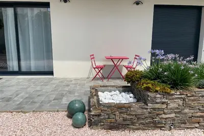 a patio with a rock fire pit and a table and chairs at Studio pour 2 personnes proche Canal du Midi - Ventenac en Minervois in Ventenac en Minervois