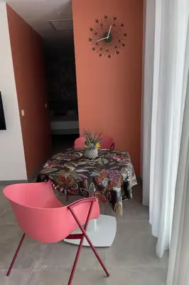 a dining room with a table and a red chair at Studio pour 2 personnes proche Canal du Midi - Ventenac en Minervois in Ventenac en Minervois