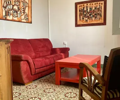a living room with a red couch and a table at Danoss Cool Stay in Narbonne