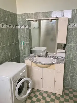 a bathroom with a washing machine and a sink at Danoss Cool Stay in Narbonne