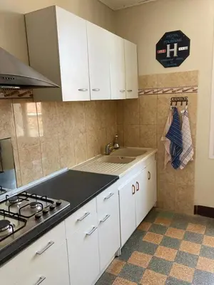 a kitchen with white cabinets and a sink and a stove at Danoss Cool Stay in Narbonne