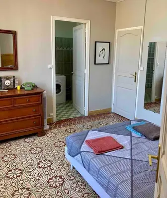 a bedroom with a bed and a dresser and a mirror at Danoss Cool Stay in Narbonne