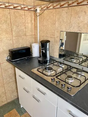a kitchen counter with a stove top and a microwave at Danoss Cool Stay in Narbonne