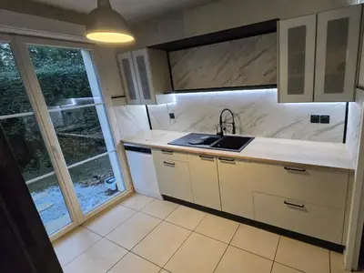 a kitchen with a sink and a large window at Villas du Golf Domaine Royal Green in Pont-de-Larn
