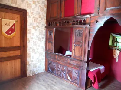 a bedroom with a wooden bed in a room at Logis de La Meschaussée, dans donjon du XIe siècle in Canet d'Aude