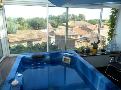 a blue tub in a room with a large window at Logis de La Meschaussée, dans donjon du XIe siècle in Canet d'Aude