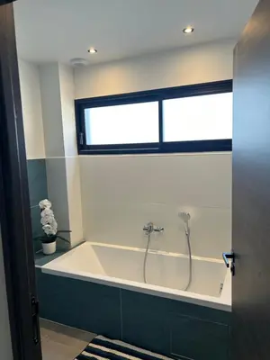 a bath tub in a bathroom with a window at Villa Catalya moderne piscine chauffée in Carcassonne