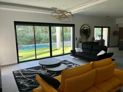 a living room with a couch and a table at Villa Catalya moderne piscine chauffée in Carcassonne