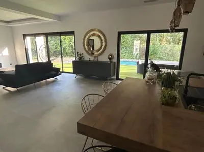a large living room with a wooden table and chairs at Villa Catalya moderne piscine chauffée in Carcassonne