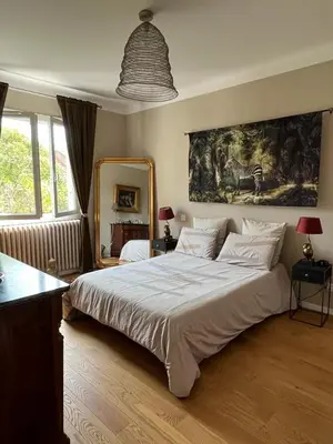 a bedroom with a large bed and a painting on the wall at Maison de charme avec jardin in Carcassonne