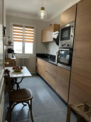a small kitchen with a table and a microwave at Maison de charme avec jardin in Carcassonne