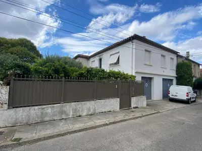 a white house with a fence and a white car at Maison de charme avec jardin in Carcassonne