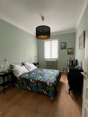 a bedroom with a bed and a desk and a window at Maison de charme avec jardin in Carcassonne